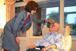 Barbara Watson carrying out an eye test on an elderly gentleman in his own home